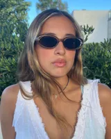 Lentes de sol con montura ovalada color marrón y cristales negros.