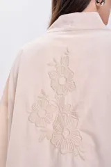 Kimono color crudo con bordado floral en la espalda, cuello mao y mangas 3/4 amplias.