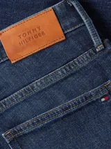 Jean Tommy Hilfiger de corte bootcut y talle medio, confeccionado en tejido denim elástico. Presenta un diseño clásico de cinco bolsillos con cierre de cremallera y botón.