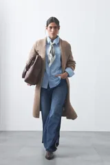 Cardigan de tejido de punto gris, con silueta larga, frente abierto, solapas clásicas y bolsillos aplicados en los laterales.