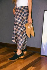 Zapato tipo botineta de gamuza negra con diseño de corte lateral, taco bajo de madera y cierre en la parte trasera.