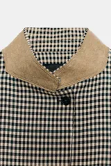 Blazer de corte estructurado con estampado de cuadros vichy en tonos neutros. Presenta cuello mao en color beige, cierre frontal con botones oscuros y bolsillos con solapa en el delantero.