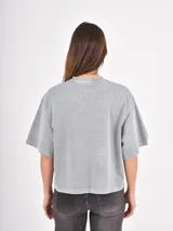 Remera de corte holgado y diseño oversize, color azul piedra con efecto lavado. Presenta un estampado gráfico frontal con tipografía y un pequeño dibujo de una rosa.