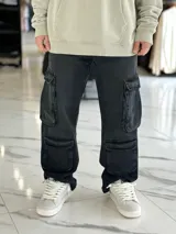 Pantalón de jean estilo cargo, color azul, de corte ancho y holgado, con múltiples bolsillos laterales en muslos y pantorrillas.