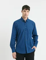 Camisa de manga larga con cuello button-down, cierre frontal con botones y bolsillo parche en el pecho. Presenta un diseño de textura sutil en color azul.