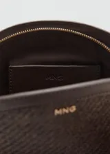 Neceser de mano de tejido de fibra natural con detalles en cuero sintético marrón oscuro, forma semicircular, cierre de cremallera y asa de muñeca.