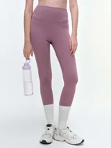 Calza deportiva de tiro alto en color violeta, confeccionada en tejido técnico elástico de alta compresión, con costuras reforzadas y diseño ajustado al cuerpo.