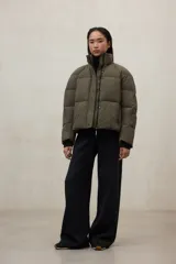 Campera acolchada negra, estilo puffer, con cuello alto y cierre frontal. Diseño oversize.