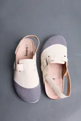 Sandalias Brokers Wear modelo Leblon White, de diseño bicolor en tonos beige y gris con puntera gris, tira ajustable con hebilla metálica y tira trasera.