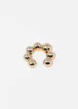 Ear cuff dorado con esferas. Se coloca en la oreja sin necesidad de perforación.