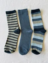 Pack de tres pares de medias de algodón hasta la media pantorrilla. Un par liso color azul, un par a rayas horizontales grises y azul marino, y un par a rayas horizontales grises, celeste y azul marino.