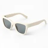 Lentes de sol Duna con armazón de policarbonato color beige y diseño rectangular con esquinas levemente angulares. Lentes oscuros con filtro UV400 y patillas gruesas.