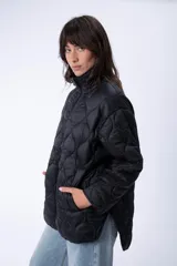 Campera negra de abrigo capitoneada con cierre frontal y cuello alto.