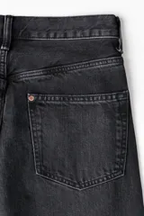 Jean de corte holgado confeccionado en denim de algodón rígido, con diseño de cinco bolsillos, tiro caído y pierna amplia redondeada.