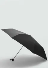 Paraguas plegable de diseño liso en color negro, con correa de mano y etiqueta metálica con logo en el lateral.