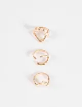 Set de tres anillos dorados con diseños irregulares y abstractos.