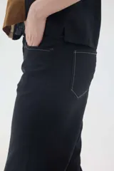 Pantalón de lino color beige, de corte recto y tiro medio, con bolsillos laterales y detalles de costuras visibles.
