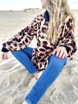 Sweater marrón con estampado animal print, cuello alto negro y mangas largas abullonadas con puños negros.