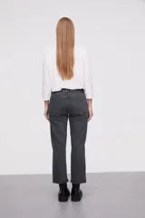 Pantalon de jean de corte recto, tiro medio, con costuras a la vista y cierre frontal con botón.