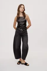 Jean de tiro medio y corte barrel con pierna amplia y ligeramente curva, estilo de cinco bolsillos en denim negro lavado.