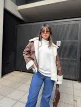 Campera tipo gamulán color marrón con interior y solapas de corderito sintético en color crema. Presenta cierre frontal, bolsillos laterales y diseño de corte holgado.