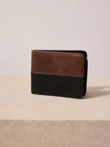 Billetera Rusty de cuero sintético bicolor, marrón y negro, con logo grabado.