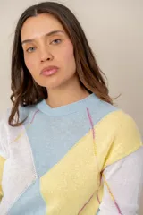 Sweater de punto de manga larga con diseño geométrico de rombos en tonos pasteles celeste, amarillo y blanco. Cuenta con cuello redondo y ribetes en el cuello, puños y ruedo.