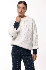 Sweater de tejido de punto con silueta relajada, cuello redondo y mangas 3/4 abullonadas con puños ajustados que aportan volumen.