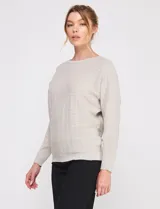 Buzo de punto calado en hilado fino, marca Allie Rose, de color gris. Presenta una silueta relajada con escote a la base, mangas largas de corte caído con puños ajustados y ruedo recto con pretina acanalada.