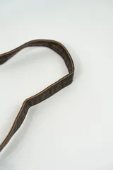 Cartera tipo baguette de cuero, color marrón oscuro, con solapa frontal y correa de hombro ajustable.