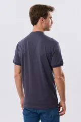 Remera estilo polo con cuello mao y manga corta, de color bordó con detalles en azul en los bordes de las mangas y cuello. Cuenta con cierre frontal parcial de tres botones y pequeño logo bordado en el pecho.