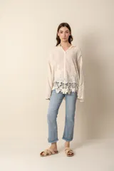 Camisa color crema con bordados florales, de corte holgado y mangas largas.