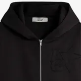 Campera negra con capucha y cierre frontal. Presenta un logo en relieve con una estrella y letras en el lado izquierdo del pecho, y un bolsillo canguro.