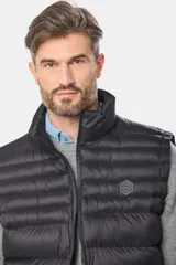 Chaleco negro capitoneado con cierre frontal y cuello alto.