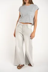 Remera gris de algodón con poliéster, corte crop, mangas cortas y bolsillo en el pecho.