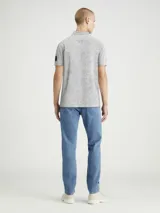 Chomba gris jaspeado de piqué de algodón peinado, con cuello clásico y tapeta de dos botones. Tiene mangas cortas, dobladillo con aberturas laterales y logo de Calvin Klein en la manga.