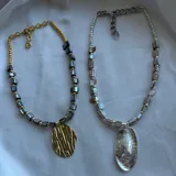 Set de dos collares con cadena dorada y plateada, con cuentas de piedra y dije ovalado.
