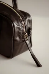 Cartera estilo baguette de cuero color marrón, con doble asa de hombro y cierre de cremallera. Hecha a mano en Uruguay.