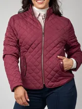 Campera matelassé color bordó, de manga larga, con cierre frontal y cuello alto con presilla. Cuenta con bolsillos frontales con tapa y broche a presión.