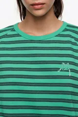 Remera corta de corte amplio confeccionada en 100% algodón, con diseño a rayas horizontales azules y negras, escote redondo, mangas cortas caídas y pequeño logo bordado en el pecho.