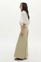 Blusa blanca con cuello mao, detalles de mini volados y bordados en el pecho y las mangas, con cierre frontal de botones y mangas largas abullonadas.
