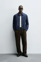 Cazadora regular fit color beige, confeccionada en tejido de algodón. Cuenta con cuello solapa, manga larga con puño elástico y trabilla, bolsillos de vivo en la cadera, bajo elástico y cierre frontal con cremallera.