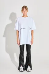 Remerón de corte oversized confeccionado en algodón, con cuello redondo y mangas cortas. Presenta estampados gráficos en color negro en la parte frontal.