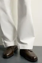 Zapato de vestir tipo derby, color marrón oscuro, con parte superior lisa, horma redonda, cordones y suela con ligero tacón.