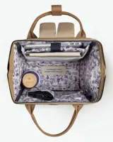 Mochila de diseño urbano en color beige con detalles en cuero sintético marrón. Cuenta con un bolsillo frontal con solapa y cierre de hebilla, asas superiores de mano y correas ajustables para hombros.