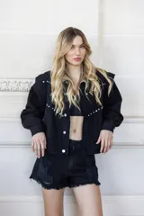 Short de jean negro de tiro alto con roturas en la pierna y ruedo desflecado.