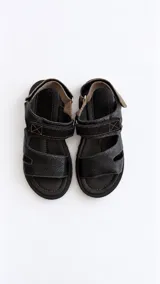 Sandalias de cuero marrón con cierre de velcro en la tira del empeine, plantilla tostada, suela flatform negra y detalles interiores en color rojo.