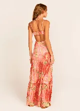 Vestido largo de tirantes finos con estampado de hojas en tonos coral, naranja, verde y amarillo. Presenta escote en V con detalle de nudo y aberturas en los laterales de la cintura.