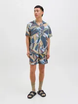 Short de baño con estampado botánico abstracto en tonos tierra, azul y gris. Cuenta con cintura elástica con cordón ajustable, bolsillos laterales y un bolsillo trasero.