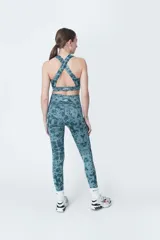 Calza deportiva larga de poliéster y elastano, color verde azulado con estampado abstracto.